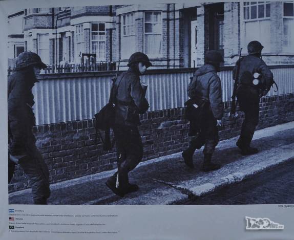 Soldados argentinos caminham em uma Port Stanley já sitiada pelos ingleses, nos últimos dias da Guerra das Malvinas (fotografia em exposição em praça de Ushuaia, no sul da Terra do Fogo, na Argentina)